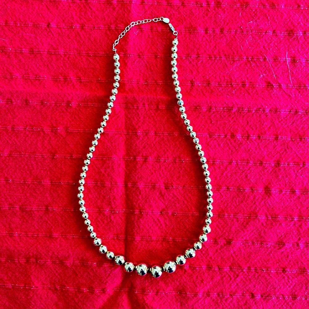 Gold tone Graduated Ball necklace. 16” - 18” long. In very good condition.